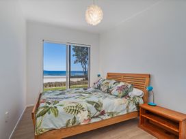 A bedroom with a bed and window view at Beachfront Beauty - Whangamata Beachfront Home Whangamata