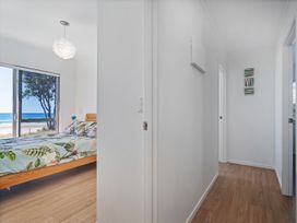 A bedroom with a bed and a window at Beachfront Beauty - Whangamata Beachfront Home Whangamata