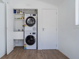 A laundry room with a washing machine and dryer at Beachfront Beauty - Whangamata Beachfront Home, Whangamata