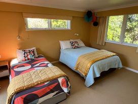 A bedroom with two beds and a bedside table at Tranquility Base - Waikanae Beach Holiday Home Waikanae Beach
