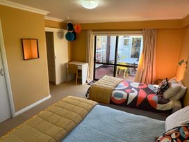 A bedroom with two beds and a desk at Tranquility Base - Waikanae Beach Holiday Home Waikanae Beach
