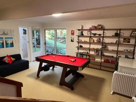 A snug with a pool table and sofa at Tranquility Base - Waikanae Beach Holiday Home Waikanae Beach