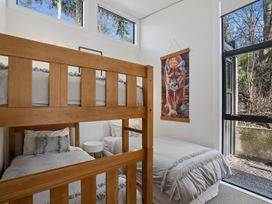 A bedroom with a bunk bed and a single bed at Merioneth Retreat - Arrowtown Holiday Home Abel Tasman National Park
