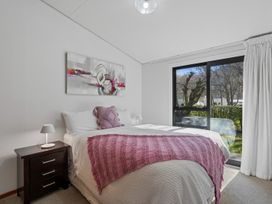A bedroom with a bed and window at Merioneth Retreat - Arrowtown Holiday Home Abel Tasman National Park