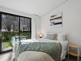 A bedroom with a bed and nightstand at Merioneth Retreat - Arrowtown Holiday Home Abel Tasman National Park