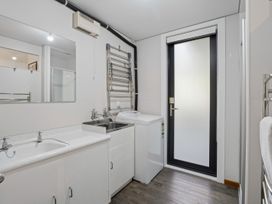 A laundry room with a washing machine and sink at Merioneth Retreat - Arrowtown Holiday Home in Abel Tasman National Park