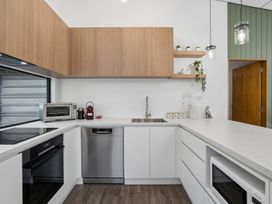 A kitchen with cabinets, sink, and appliances at Merioneth Retreat - Arrowtown Holiday Home