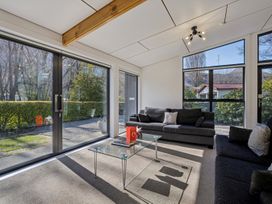 A living room with large windows and sofas at Merioneth Retreat - Arrowtown Holiday Home Abel Tasman National Park