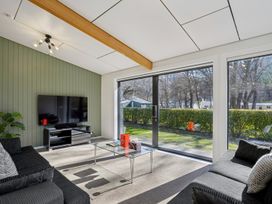 A living room with a television and a coffee table at Merioneth Retreat - Arrowtown Holiday Home Abel Tasman National Park