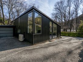 A house with large windows and a garage at Merioneth Retreat - Arrowtown Holiday Home Abel Tasman National Park