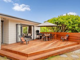 An outdoor deck with a table and chairs at Slice of Pauanui - Pauanui Holiday Home, Pauanui