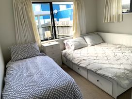 A bedroom with two beds and a lamp at Whangamata Beach Break - Whangamata