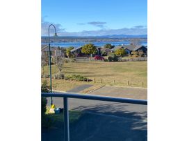 A view of houses and a lake with mountains in the background at Lake View Bliss - Lake Taupo Holiday Home, Lake Taupo