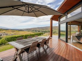 An outdoor dining area with a table and chairs at Vino and Views - Bannockburn Holiday Home Cromwell