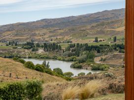 A landscape view featuring mountains, a river, and trees at Vino and Views - Bannockburn Holiday Home, Cromwell