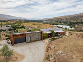 An aerial view of a house next to a river at Vino and Views - Bannockburn Holiday Home Cromwell