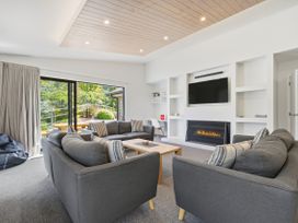 A living room with a fireplace and television at Rolki House - Hanmer Springs