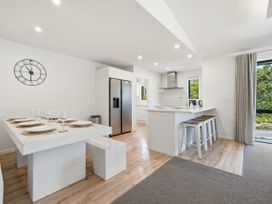 A kitchen with a dining table and refrigerator at Rolki House - Hanmer Springs Holiday Home, Hanmer Springs