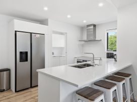 A kitchen with a refrigerator, sink, and stove at Rolki House - Hanmer Springs