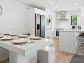 A kitchen with a dining table and modern appliances at Rolki House - Hanmer Springs