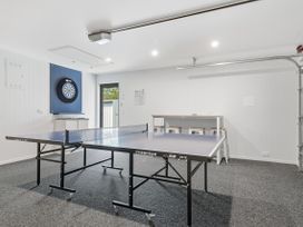 A game room with a ping pong table and darts board at Rolki House - Hanmer Springs