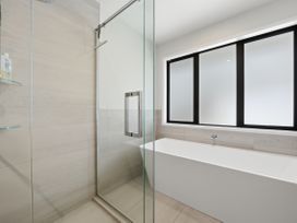 A bathroom with a shower and bathtub at Rolki House - Hanmer Springs