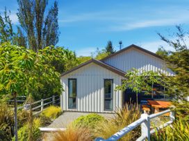 A house with seating area surrounded by trees at Rolki House - Hanmer Springs