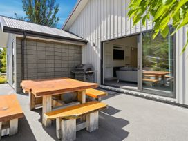 An outdoor seating area with a table and benches at Rolki House - Hanmer Springs