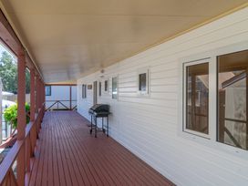 An outdoor deck area with a grill at Poppy's Beach House - Beachfront Whangapoua Home