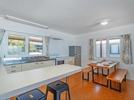 A kitchen with a dining table and chairs at Poppy's Beach House - Beachfront Whangapoua Home