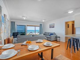 A living room with a dining area and view at Poppy's Beach House - Beachfront Whangapoua Home Whangapoua