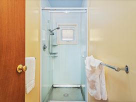 A shower with towels on a rack at Poppy's Beach House - Beachfront Whangapoua Home