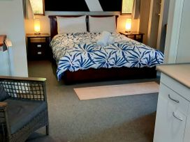 A bedroom with a bed and bedside tables at Havenbrooke - Kerikeri Holiday Home Kerikeri