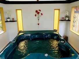 A jacuzzi with flowers and candles in a bathroom at Havenbrooke - Kerikeri Holiday Home in Kerikeri