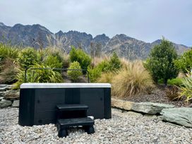 A hot tub with steps and gravel in an outdoor area at A Remarkable Stay - Jack's Point Holiday Home, Queenstown