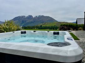 A hot tub with a mountain view at A Remarkable Stay - Jack's Point Holiday Home, Queenstown