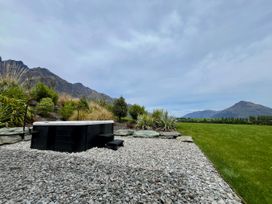 A hot tub and gravel area with mountains in the background at A Remarkable Stay - Jack's Point Holiday Home, Queenstown