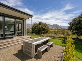 An outdoor area with a wooden table and benches at Bull Ridge Escape - Wanaka