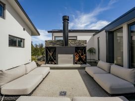 An outdoor seating area with a fireplace at Bull Ridge Escape - Wanaka