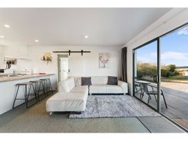 A living room with a sofa and stools at Adventure Seekers Lodge - National Park Retreat