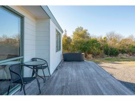 An outdoor area with a deck, table, and chairs at Adventure Seekers Lodge - National Park Retreat