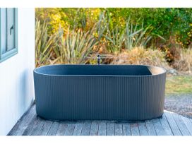 A bathtub with a faucet on wooden decking at Adventure Seekers Lodge - National Park Retreat in National Park