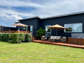 An outdoor area with seating and a hot tub at SeaRenity - Waimarama Holiday Home Waimarama