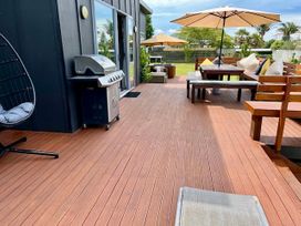 An outdoor deck with a grill and seating area at SeaRenity - Waimarama Holiday Home in Waimarama