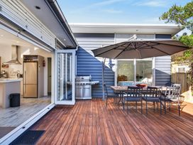 An outdoor patio with a grill and dining table at Pohutukawa Peace - Mangawhai Holiday Home in Mangawhai Village