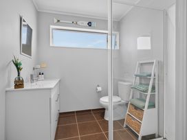 A bathroom with a shower, sink, and toilet at Pohutukawa Peace - Mangawhai Holiday Home, Mangawhai Village