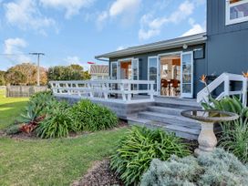 A house with a deck and garden at Matapouri Magic - Matapouri
