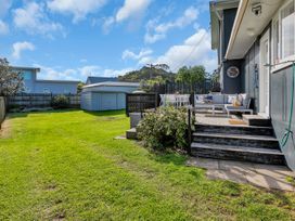 A garden with grass, chairs, and a table at Matapouri Magic - Matapouri