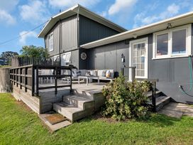 An outdoor deck with seating and a table at Matapouri Magic - Matapouri