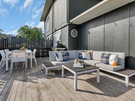 An outdoor patio with a sofa and dining set at Matapouri Magic - Matapouri